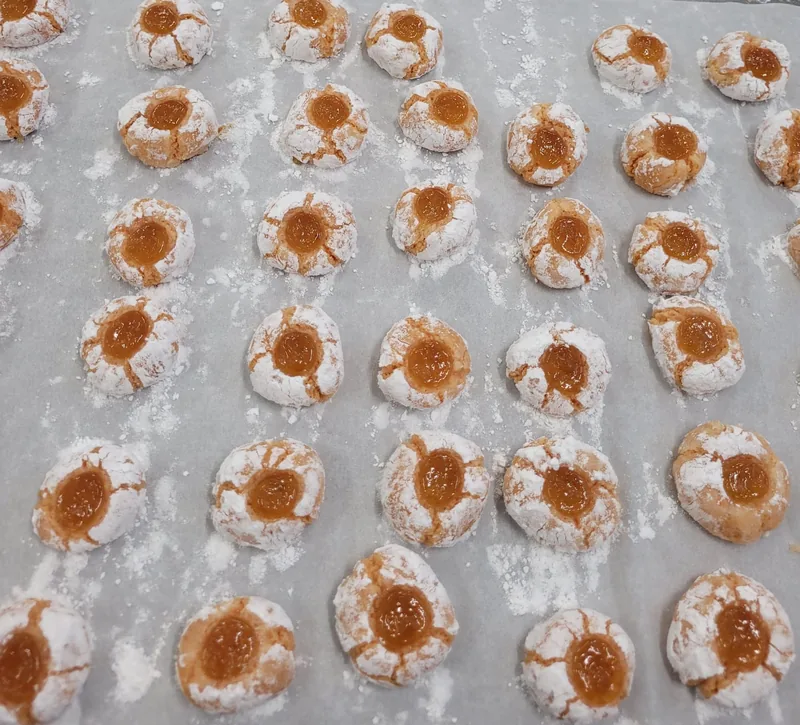 Amaretti screpolati nello zucchero a velo, con un cuore di confettura d'albicocca