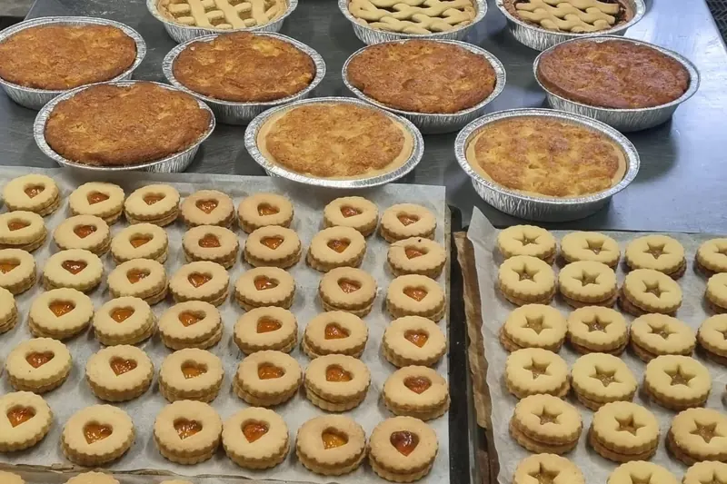 Crostate e biscotti a cuore e a stella sul banco del laboratorio