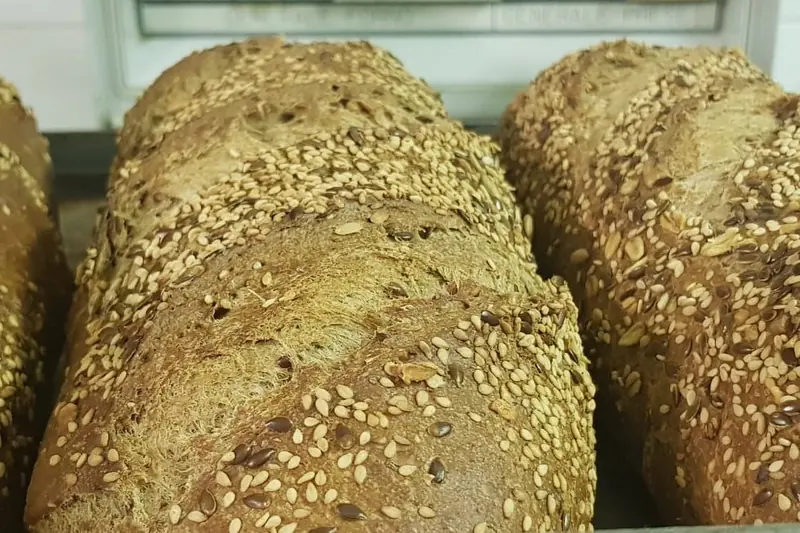 Filoni di pane ai semi appena cotti sul carrello del laboratorio