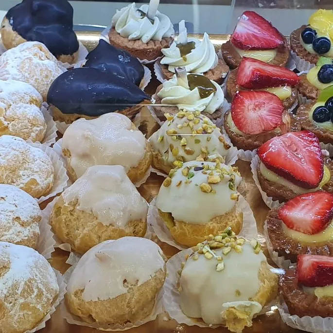 Bignè glassati, éclair al cioccolato, cestini con crema e tartellette alle fragole