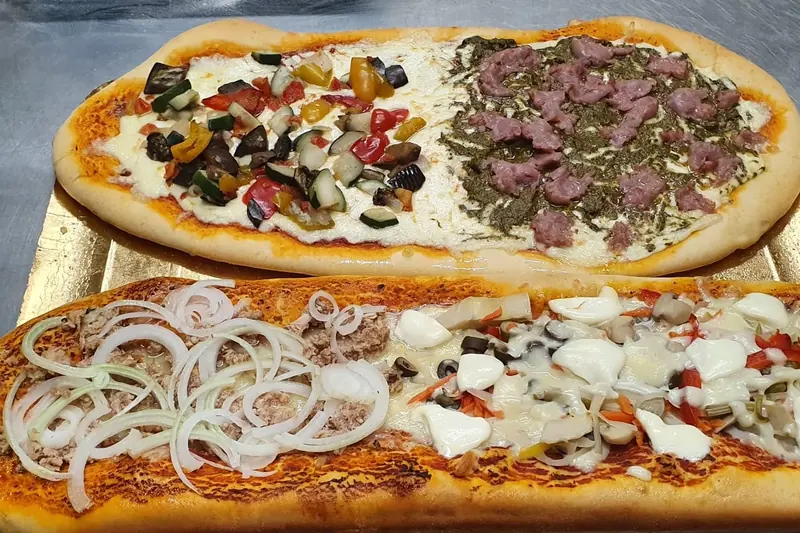 Due pizze lunghe con verdure grigliate, salsiccia, tonno e cipolla