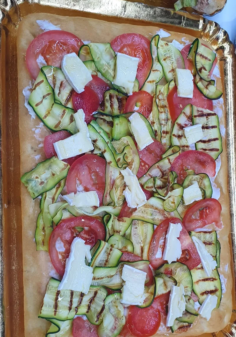 Focaccia farcita con zucchine grigliate, fette di pomodoro e formaggio