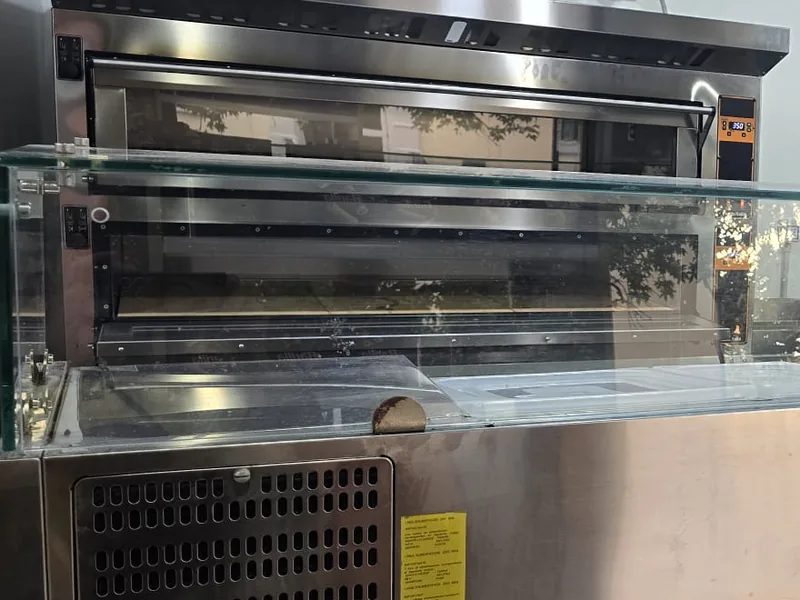 La postazione nuova per la pizza della sera: il forno a piani e il banco refrigerato a vetro